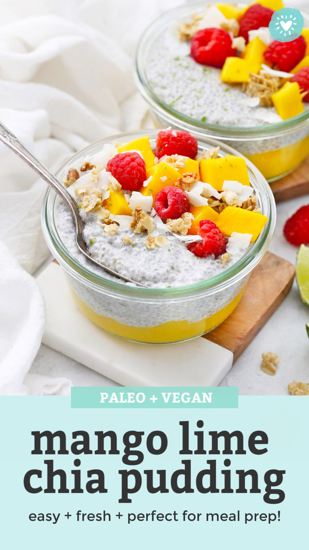 Front View of Jars of Mango Chia Pudding Topped with Raspberries, Granola, and Fresh Mango with text that reads "Paleo & Vegan Mango Lime Chia Pudding. Easy + Fresh + Perfect for meal prep!"