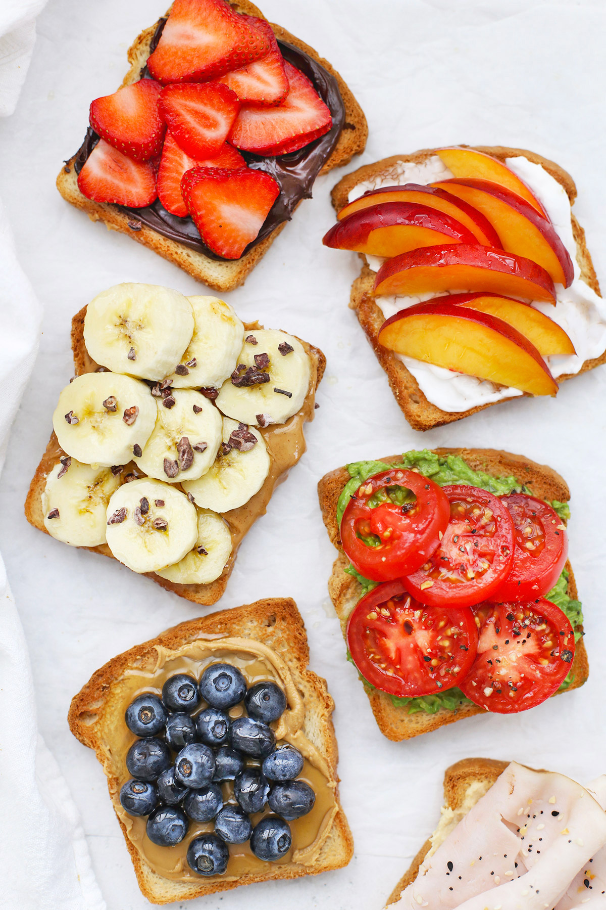 Six Slices of Gluten-Free toast with different toppings on a white background.