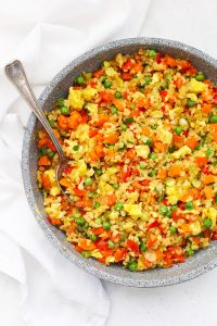 Cauliflower Fried Rice in a nonstick ceramic skillet on a white background.