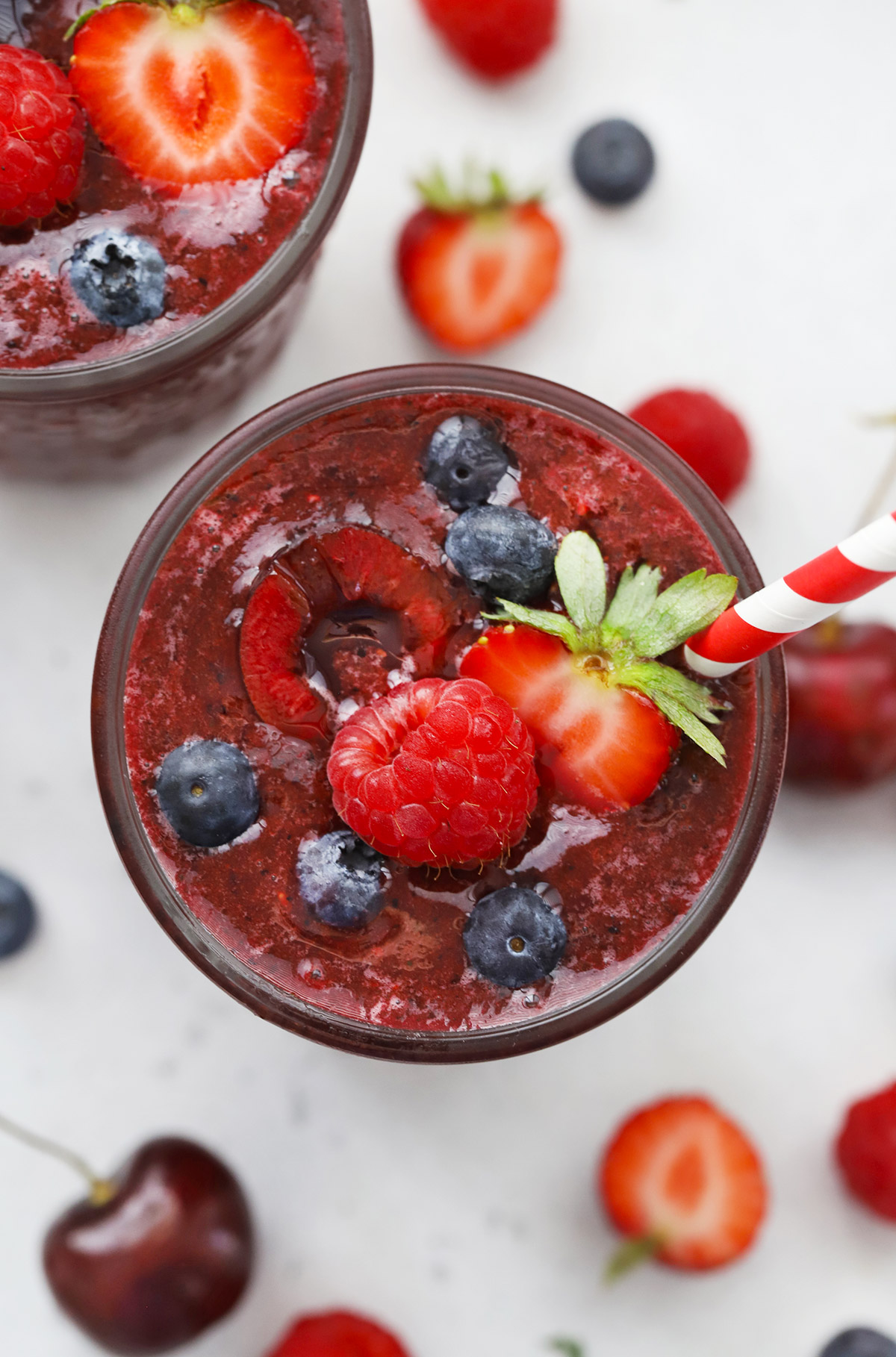 Close up view of Cherry Berry Smoothie topped with fresh berries and cherries