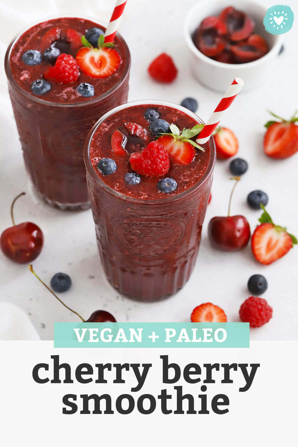 Front view of Cherry Berry Smoothies topped with fresh berries and cherries with text overlay that reads "Vegan + Paleo Cherry Berry Smoothie"