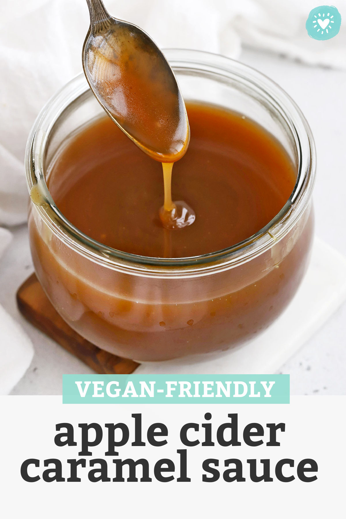 Spoon Drizzling Apple Cider Caramel Sauce into a jar with text overlay that reads "Vegan-Friendly Apple Cider Caramel Sauce"