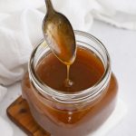 Spoon Drizzling Apple Cider Caramel Sauce into a jar