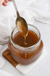 Spoon Drizzling Apple Cider Caramel Sauce into a jar