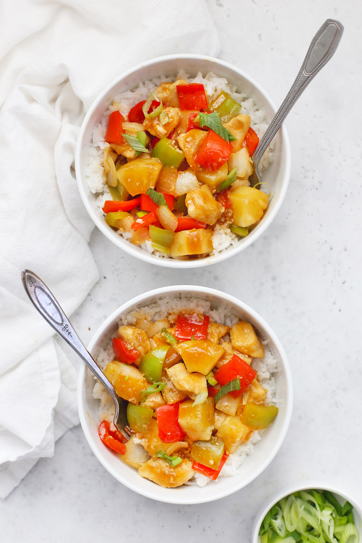 Two bowls of Healthy Sweet and Sour Chicken on a white background