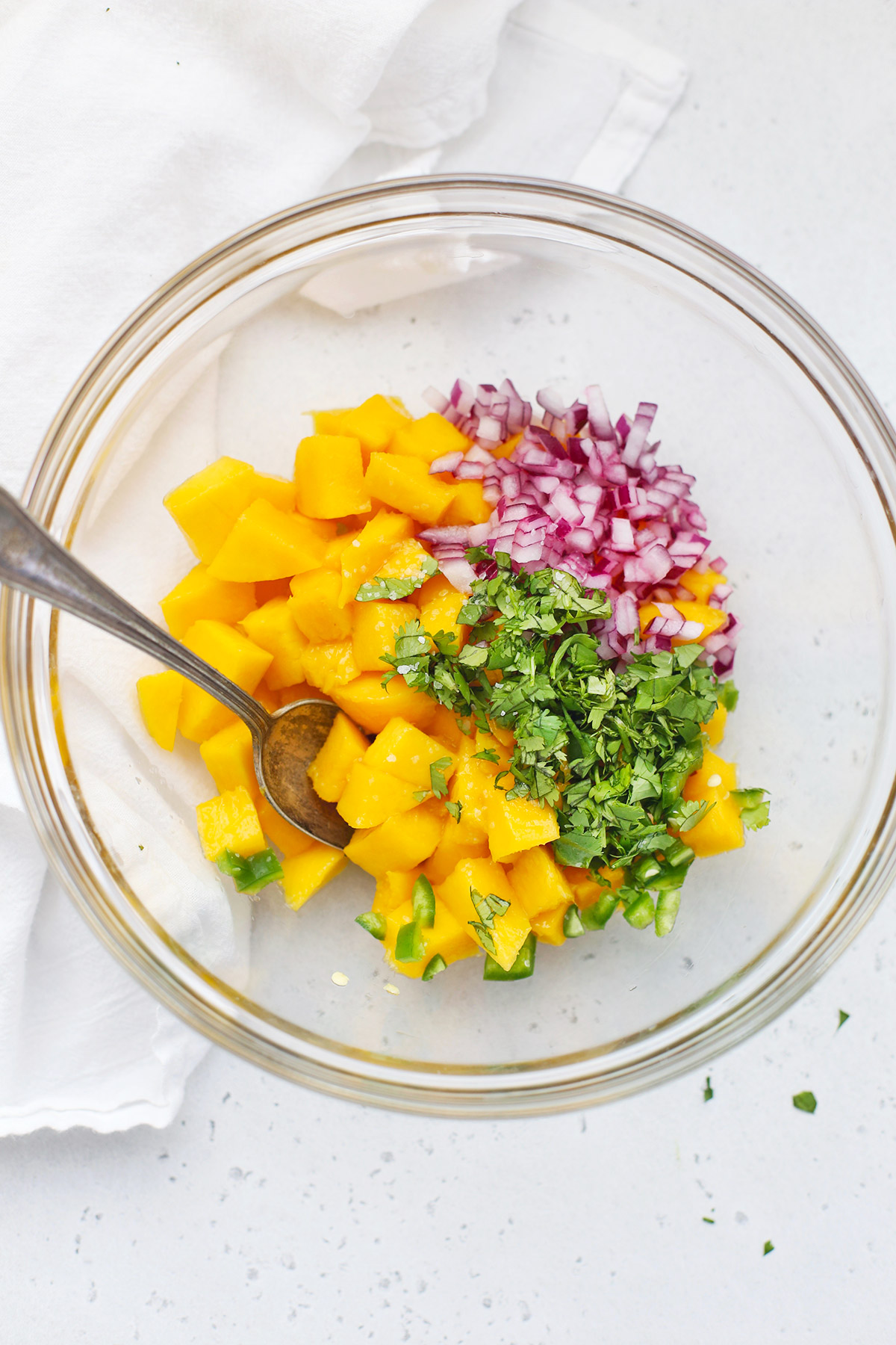 Ingredients of mango salsa in a glass bowl