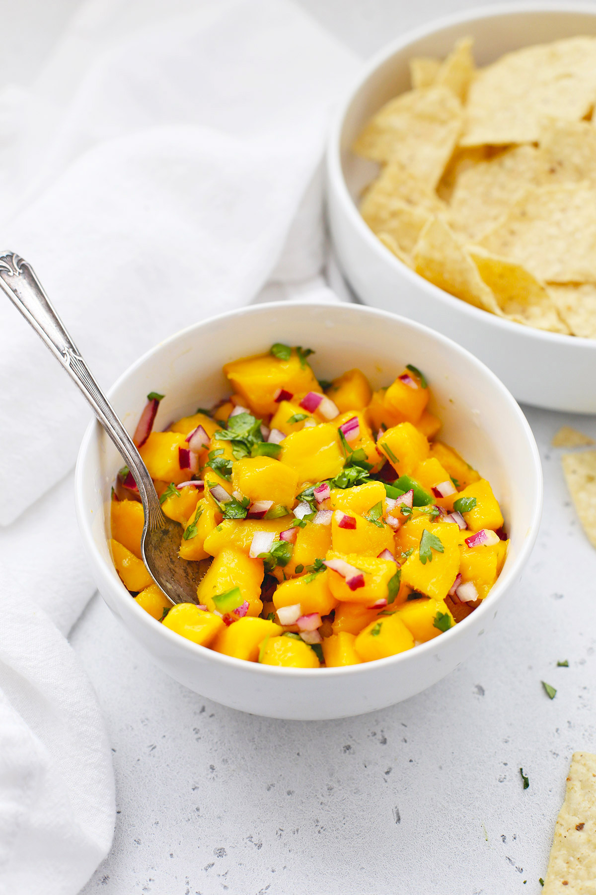 Bowl of fresh mango salsa in a bowl with tortilla chips in the background