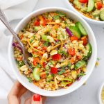 Setting down two bowls of Thai Quinoa Salad with Peanut Dressing