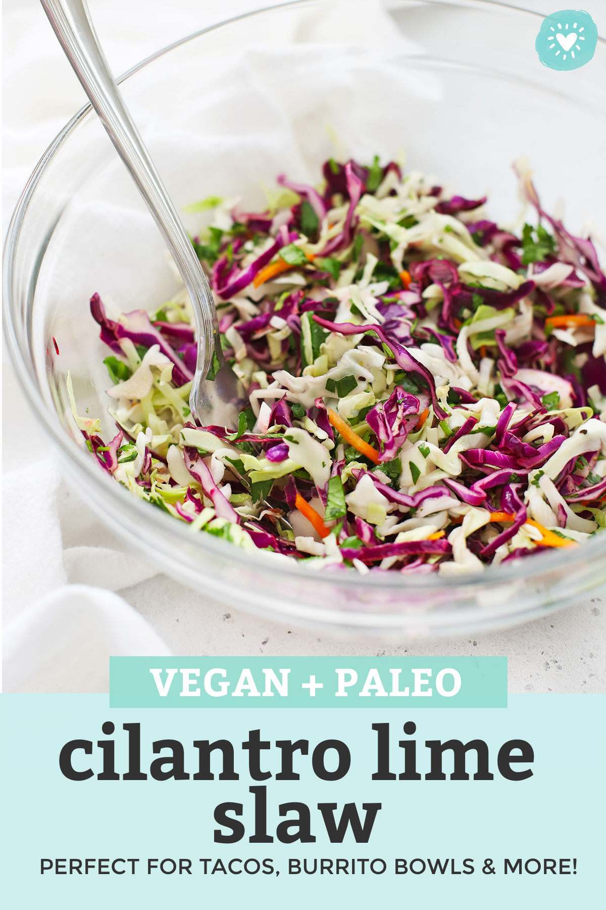 Freshly mixed Cilantro Lime Slaw in a Glass Bowl with text overlay that reads "Vegan + Paleo Cilantro Lime Slaw. Perfect for tacos, burrito bowls, and more!"