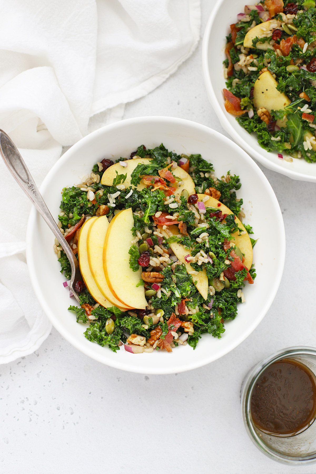 Overhead view of bowls of Harvest Apple Kale Salad with Balsamic Dressing