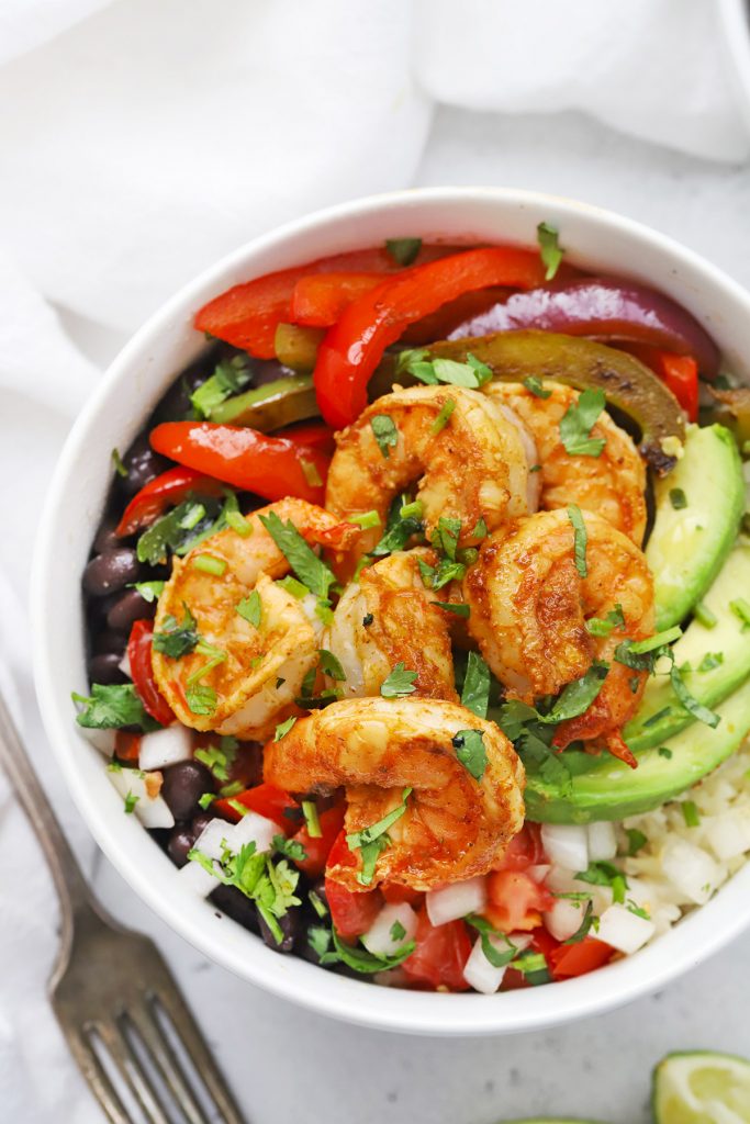 Close-up view of a Shrimp Fajita Bowl with cauliflower rice, avocado, and black beans