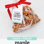 A gift bag of Maple Candied Pecans with free printable gift tag and red polka dot ribbon with text overlay that reads "Paleo + Vegan Maple Candied Pecans + Free Printable Gift Tags!"