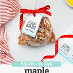 An overhead view of a gift bag of naturally sweetened maple candied pecans with free printable gift tag and red polka dot ribbon with text overlay that reads "Paleo + Vegan Maple Candied Pecans + Free Printable Gift Tags!"