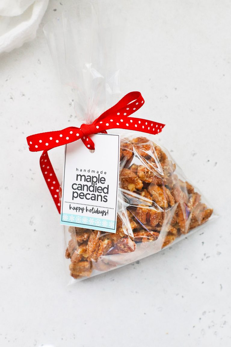 A gift bag of Maple Candied Pecans with free printable gift tag and red polka dot ribbon