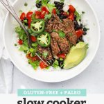 Overhead view of a Slow Cooker Barbacoa Beef burrito bowl with rice, black beans, lettuce, pico de gallo, avocado, and more with text overlay that reads "Gluten-Free + Paleo Slow Cooker Barbacoa Beef"