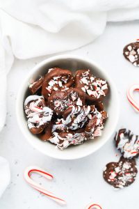 Overhead view of a red and white striped bowl of gluten-free chocolate peppermint pretzels.