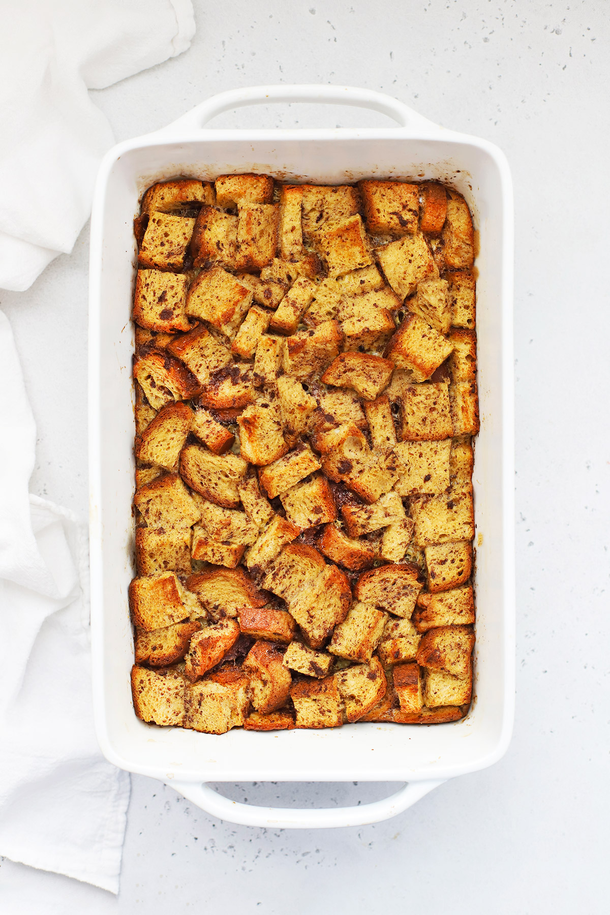 Overhead view of overnight gluten-free french toast casserole topped in a white baking dish