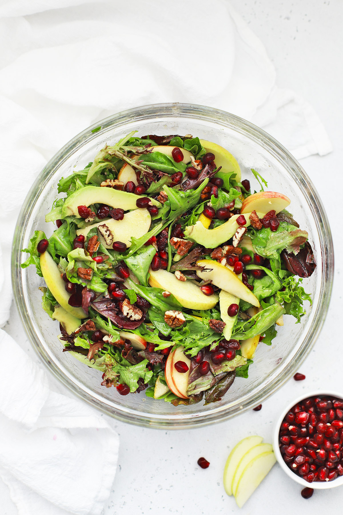 Overhead view of pear pomegranate salad in a glass bowl