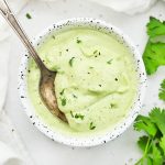 Overhead view of a speckled bowl of vegan or paleo avocado ranch