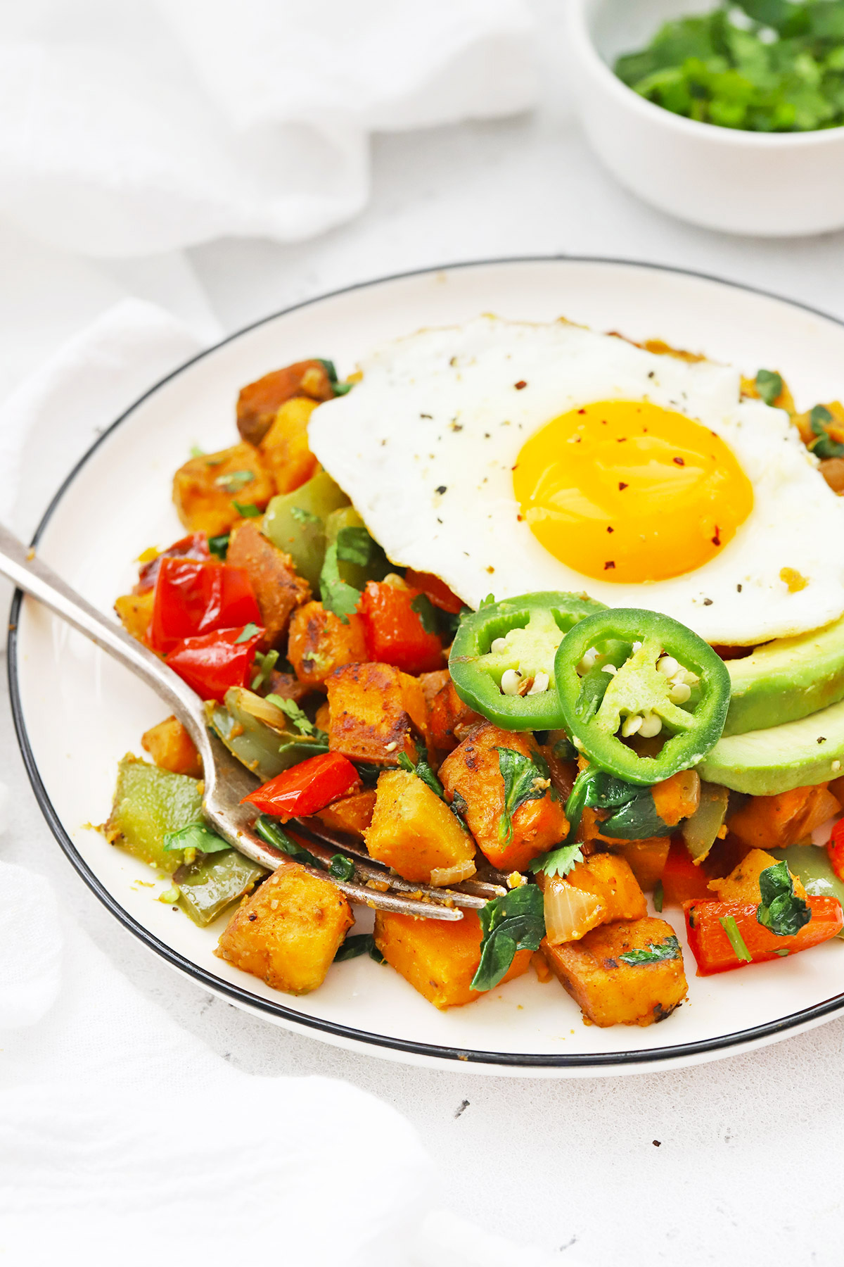 Front view of a plate of Vegan Sweet Potato Hash topped with an egg