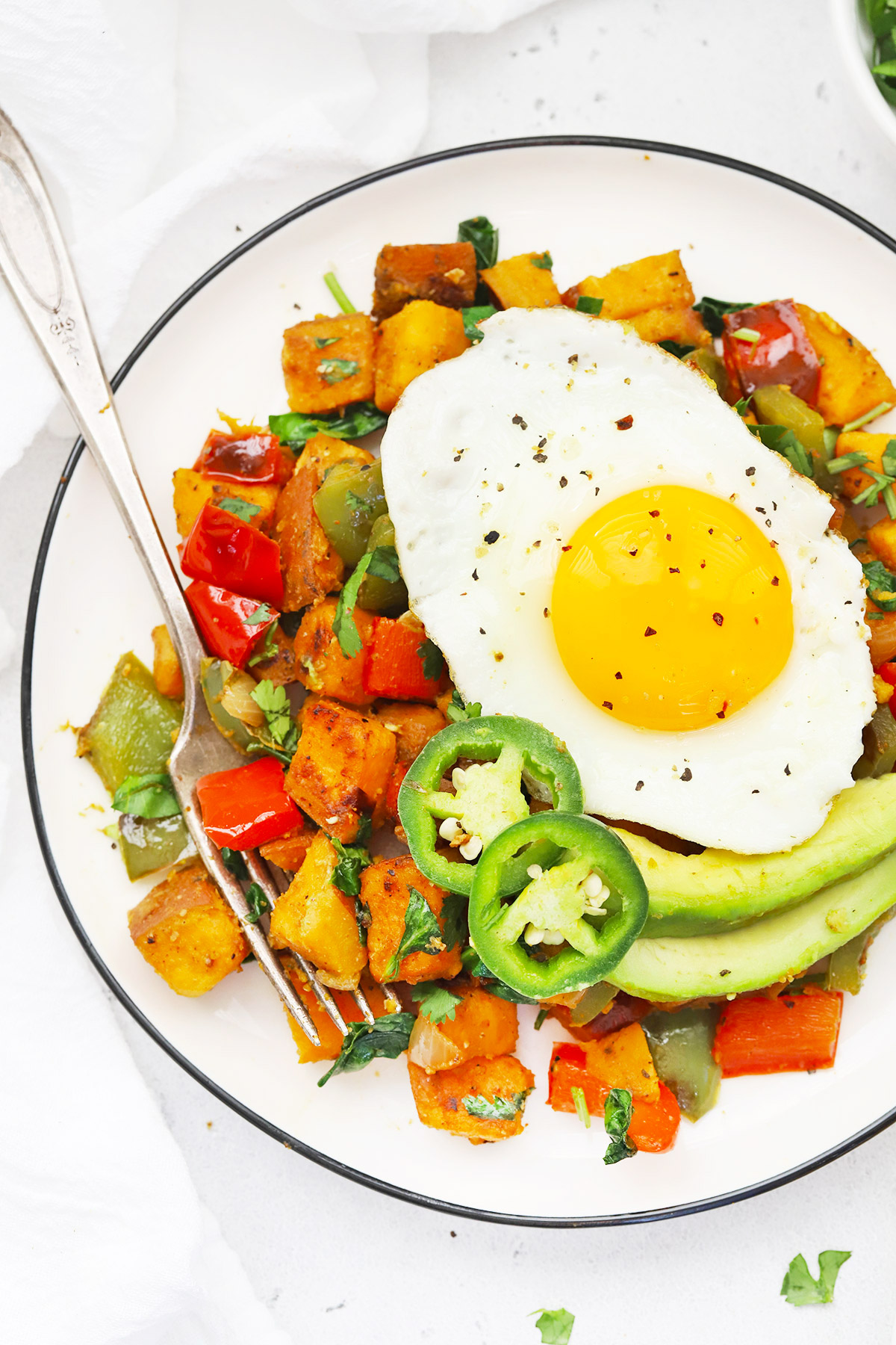 Close up overhead view of a plate of Southwest Sweet Potato Hash topped with an egg
