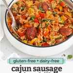 Front view of a bowl of Cajun Sausage and Rice Skillet on a white background with text overlay that reads "gluten-free + dairy-free Cajun sausage + rice skillet. An easy one-pan dinner!"