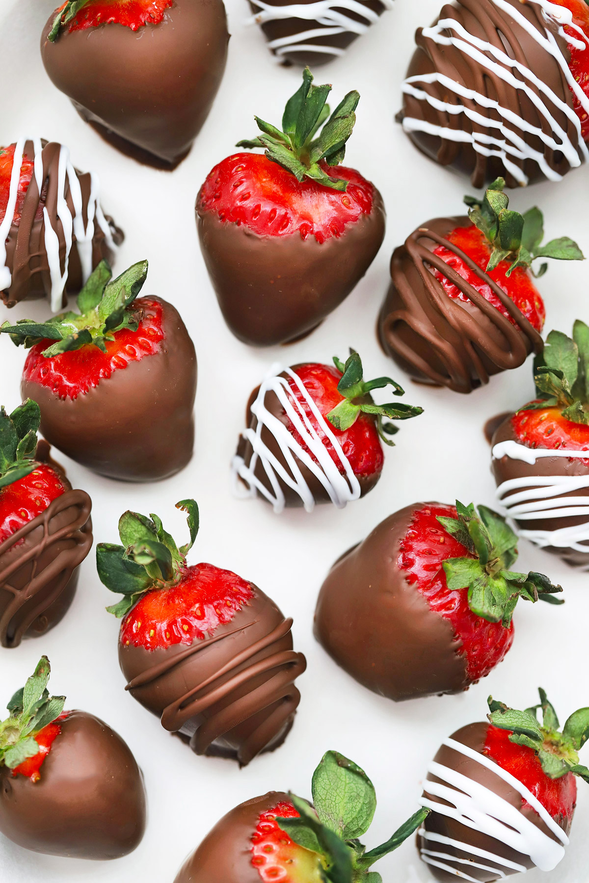 Overhead view of vegan chocolate-covered strawberries on a white background