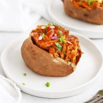 Close up Front view of a BBQ Chicken Stuffed Baked Sweet Potato on a white plate
