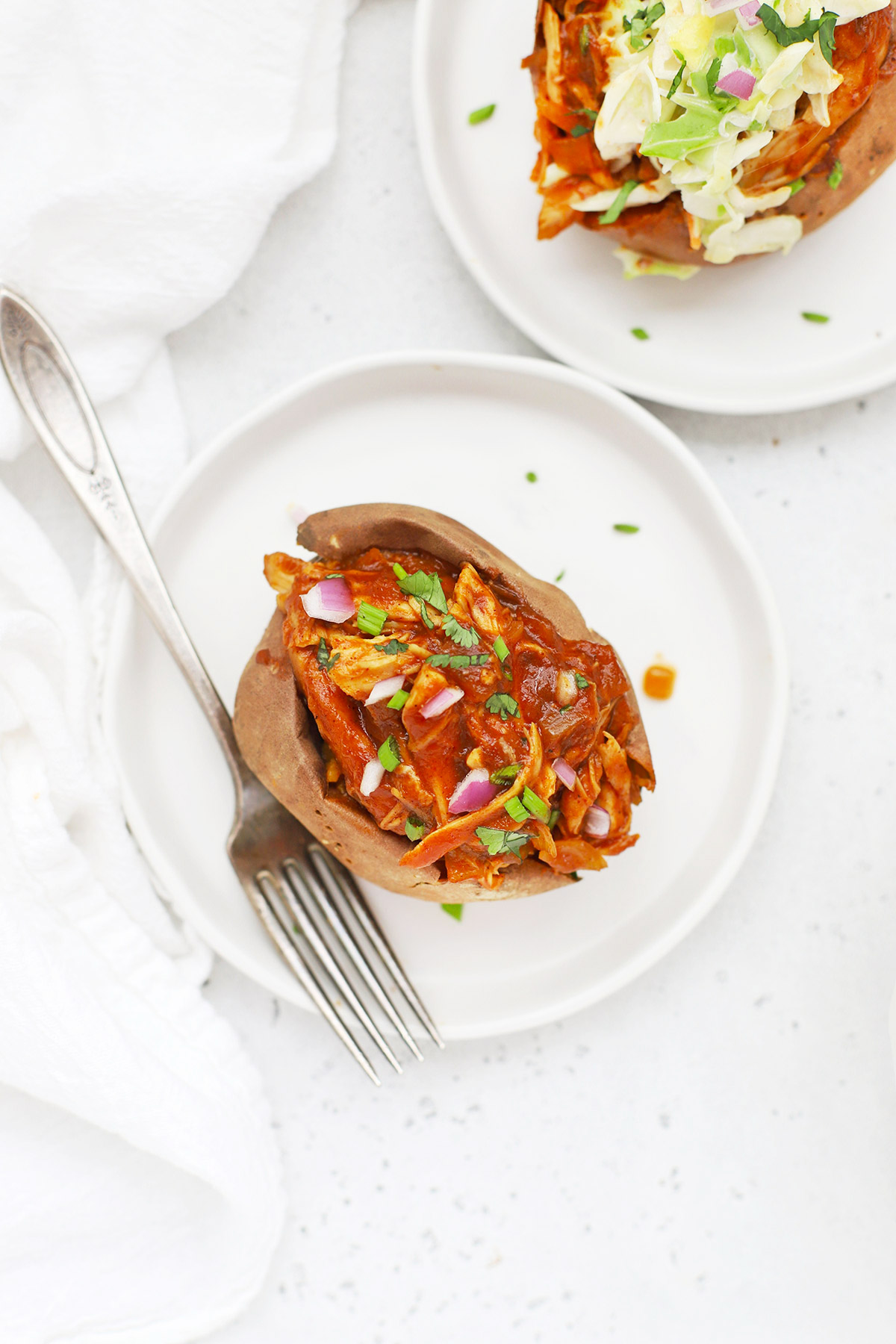 Overhead view of a BBQ Chicken Stuffed Baked Sweet Potato on a white plate