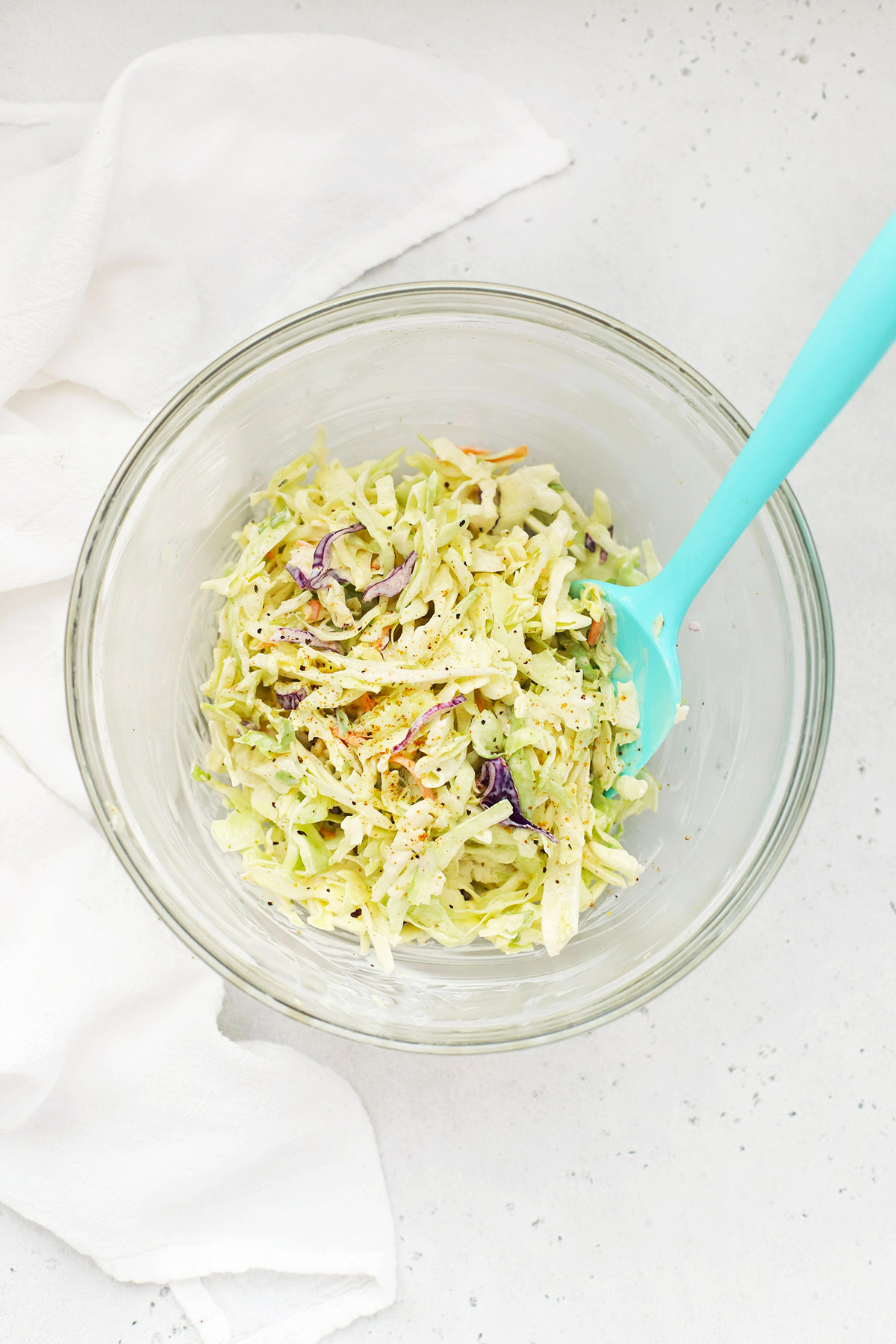 Overhead view of a bowl of coleslaw on a white background