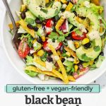Close up overhead view of a white bowl of vegetarian black bean taco salad with crispy torilla strips and chipotle ranch dressing with text overlay that reads "gluten-free + vegan-friendly black bean taco salad with chipotle ranch dressing"