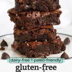 Front view of gluten-free brownie squares stacked up on a white plate with text overlay that reads "dairy-free + paleo-friendly gluten-free brownies"