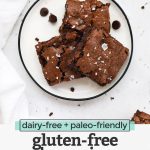 Overhead view of gluten-free brownie squares on a white plate with text overlay that reads "dairy-free + paleo-friendly gluten-free brownies"