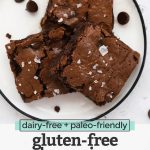 Close up view of gluten-free brownie squares on a white plate with text overlay that reads "dairy-free + paleo-friendly gluten-free brownies"