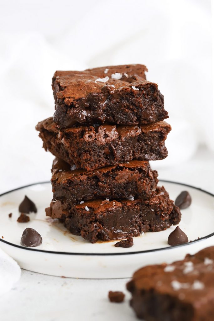 Front view of gluten-free brownie squares stacked up on a white plate