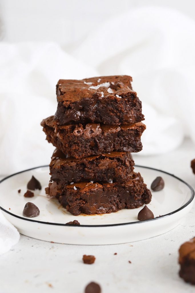 Front view of gluten-free brownie squares stacked up on a white plate