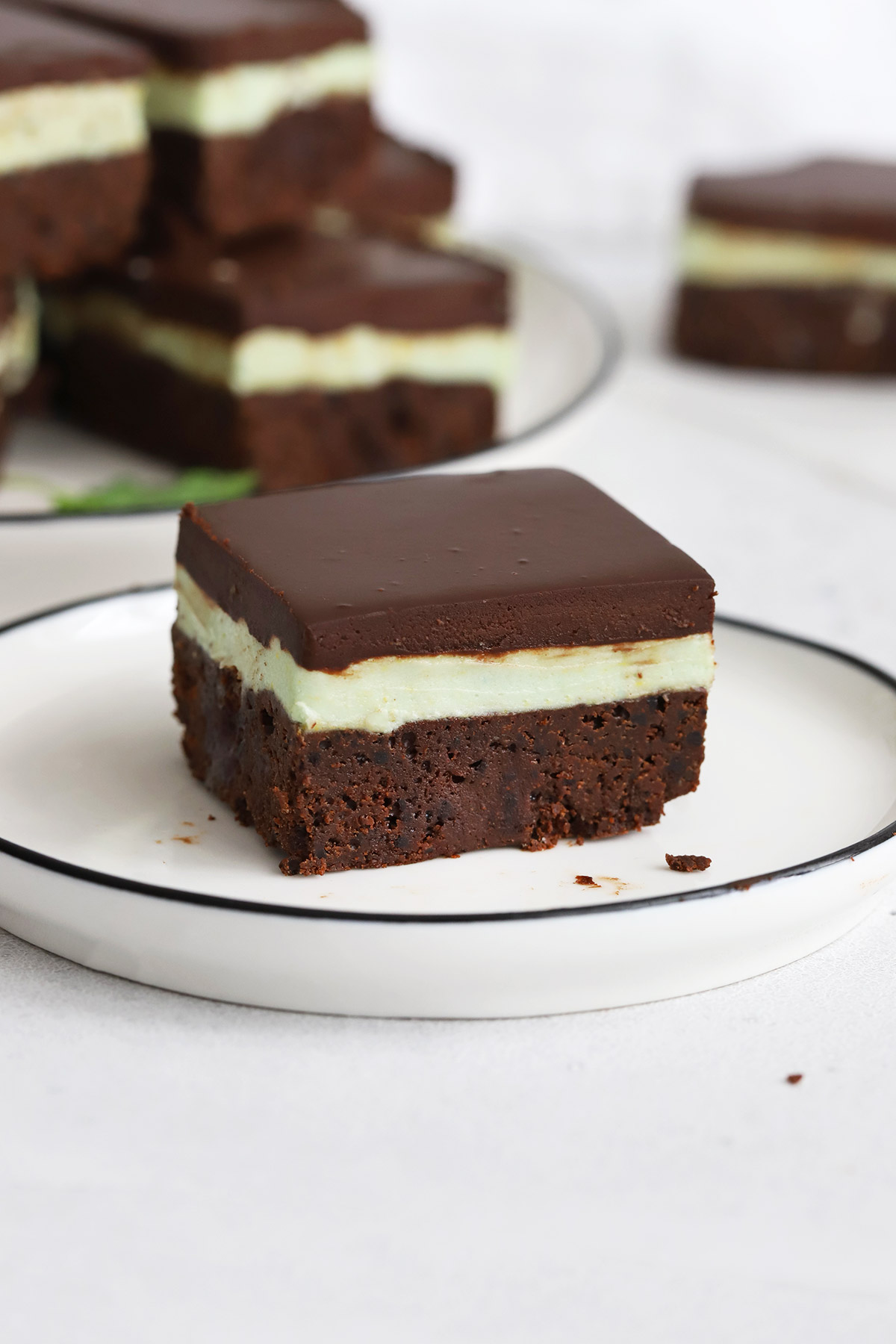 Front view of a gluten-free mint brownie square on a white plate.