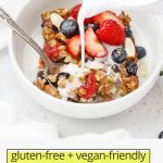 Front view of a slice of mixed berry baked oatmeal topped with fresh berries and sliced almonds with almond milk being poured on top with text overlay that reads "gluten-free + vegan-friendly mixed berry baked oatmeal"