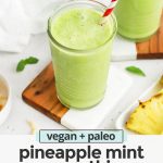 Front view of a glass of pineapple mint smoothie with a red striped straw with text overlay that reads "vegan + paleo pineapple mint smoothie. Fresh + easy + delicious"