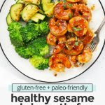 Close up overhead view of a plate of easy sesame shrimp with broccoli and zucchini on a white background with text overlay that reads "gluten-free + paleo-friendly healthy sesame shrimp stir-fry. Quick + easy + yumm!"