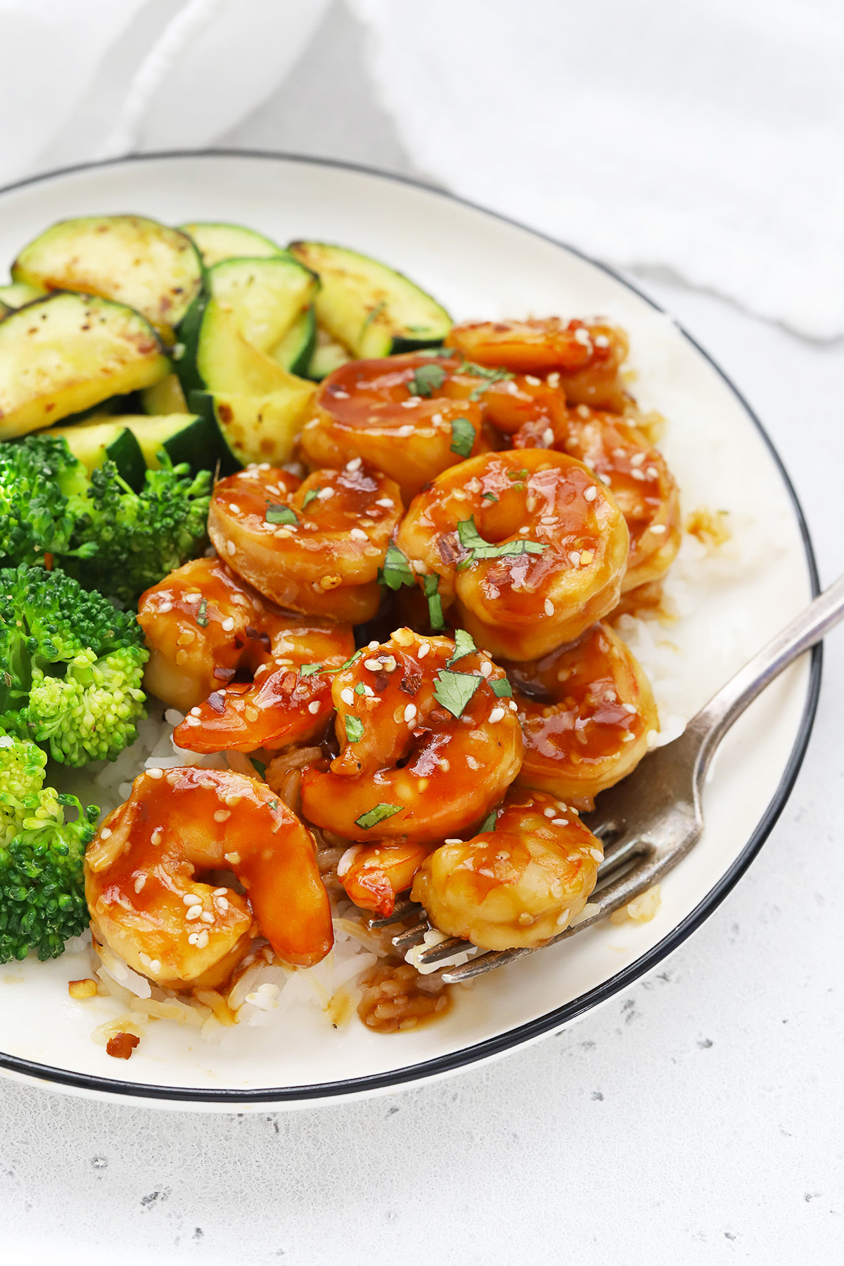 Front view of a plate of easy sesame shrimp with broccoli and zucchini