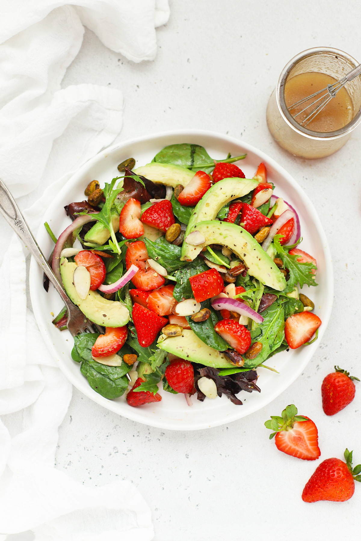 Overhead view of strawberry spinach salad on a white salad plate