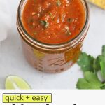 Front view of a jar of chipotle salsa with a platter of tortilla chips on a white background with text overlay that reads "quick + easy chipotle salsa: smoky + flavorfu; + delicious"