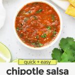 Overhead view of a bowl of chipotle salsa on a white background with tortilla chips with text overlay that reads "quick + easy chipotle salsa: smoky + flavorfu; + delicious"