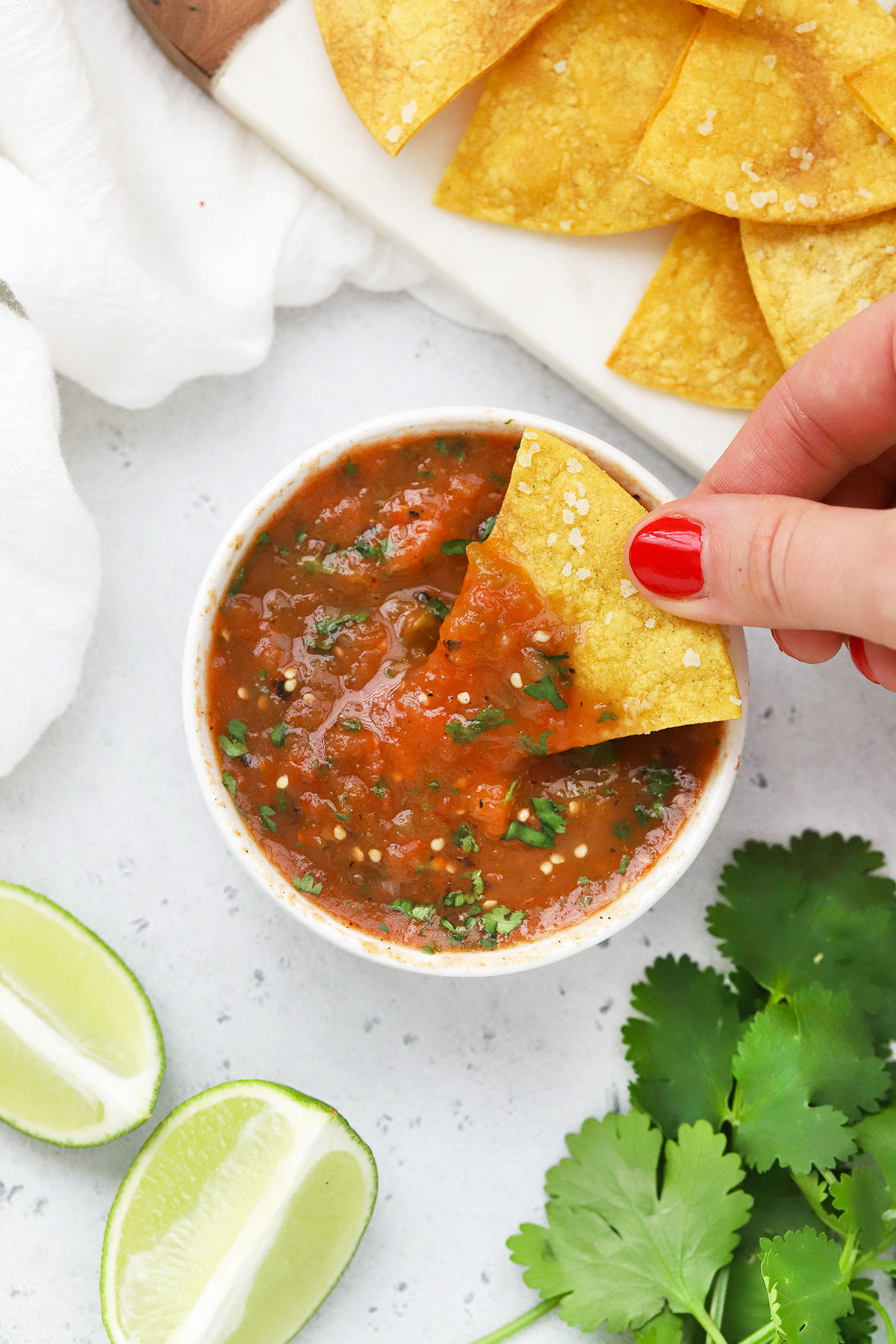 Overhead view of a bowl of chipotle salsa on a white background with tortilla chips