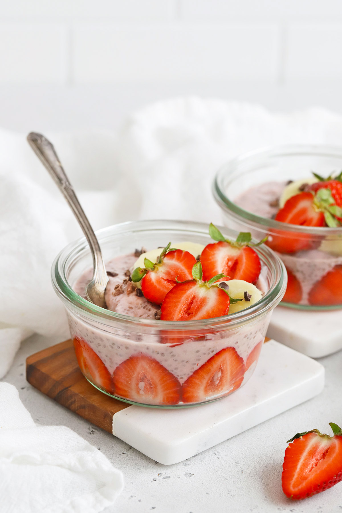 Front view of jars of strawberry chia pudding on a white background