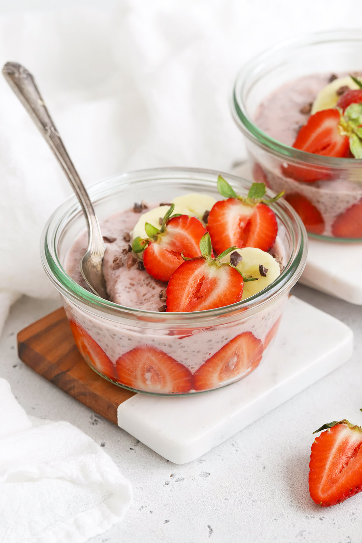Close up front view of jars of strawberry chia pudding on a white background
