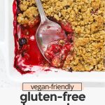 Overhead view of a baking dish of gluten-free berry crisp with a serving spoon with text overlay that reads "vegan-friendly gluten-free berry crisp: gorgeous + easy + delicious"