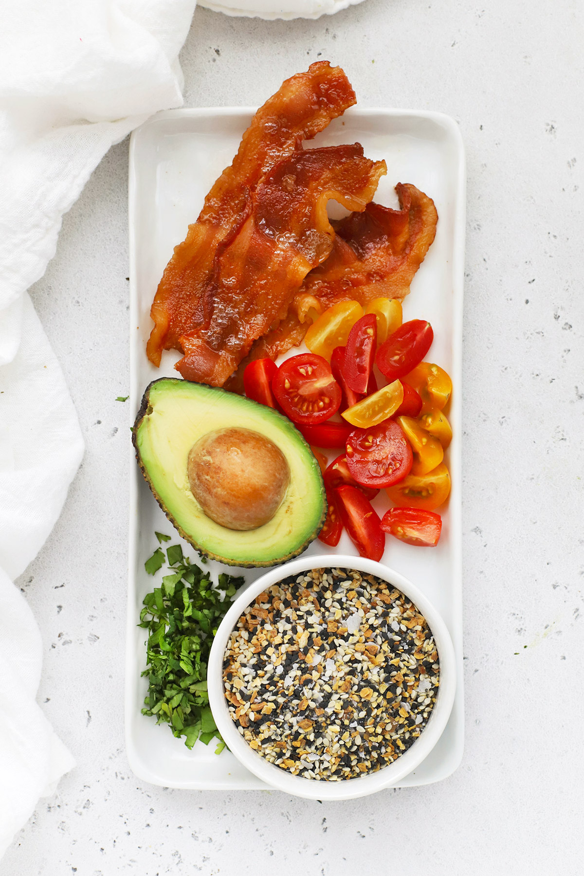 Overhead view of a platter of toppings for California Breakfast Stuffed Sweet Potatoes