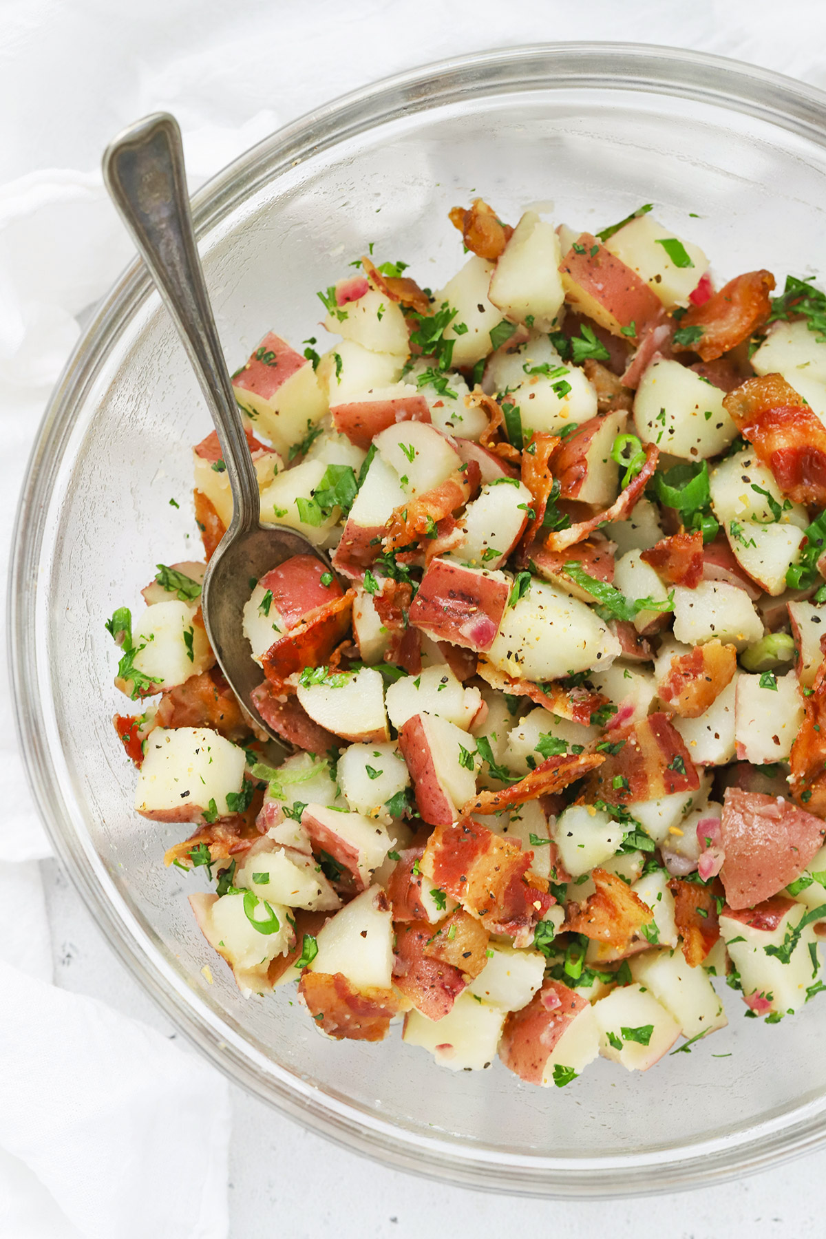 Overhead view of a glass bowl of German Potato Salad with Bacon Dressing